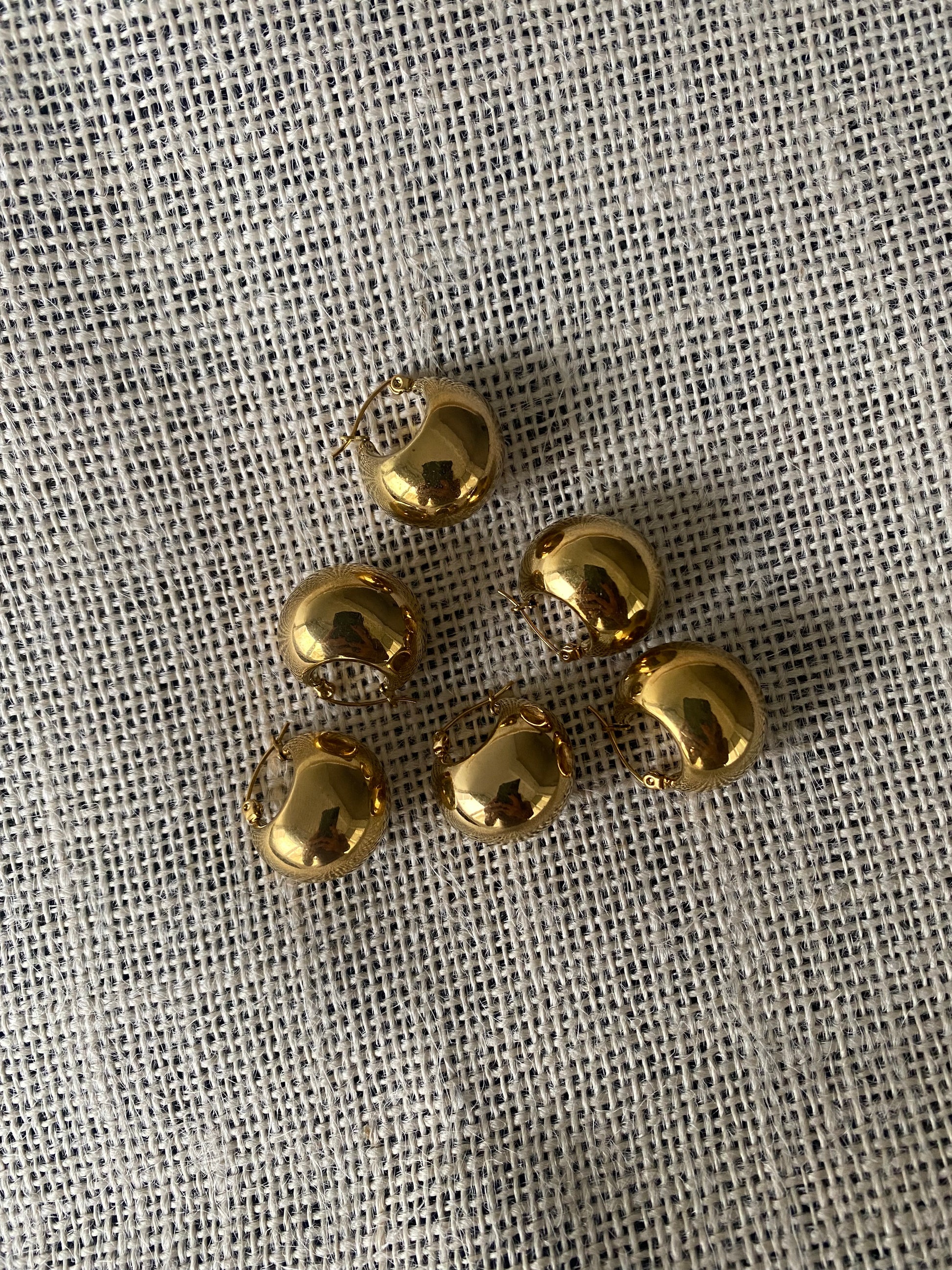 Brincos redondos, em balão, de aço inoxidável dourado. 