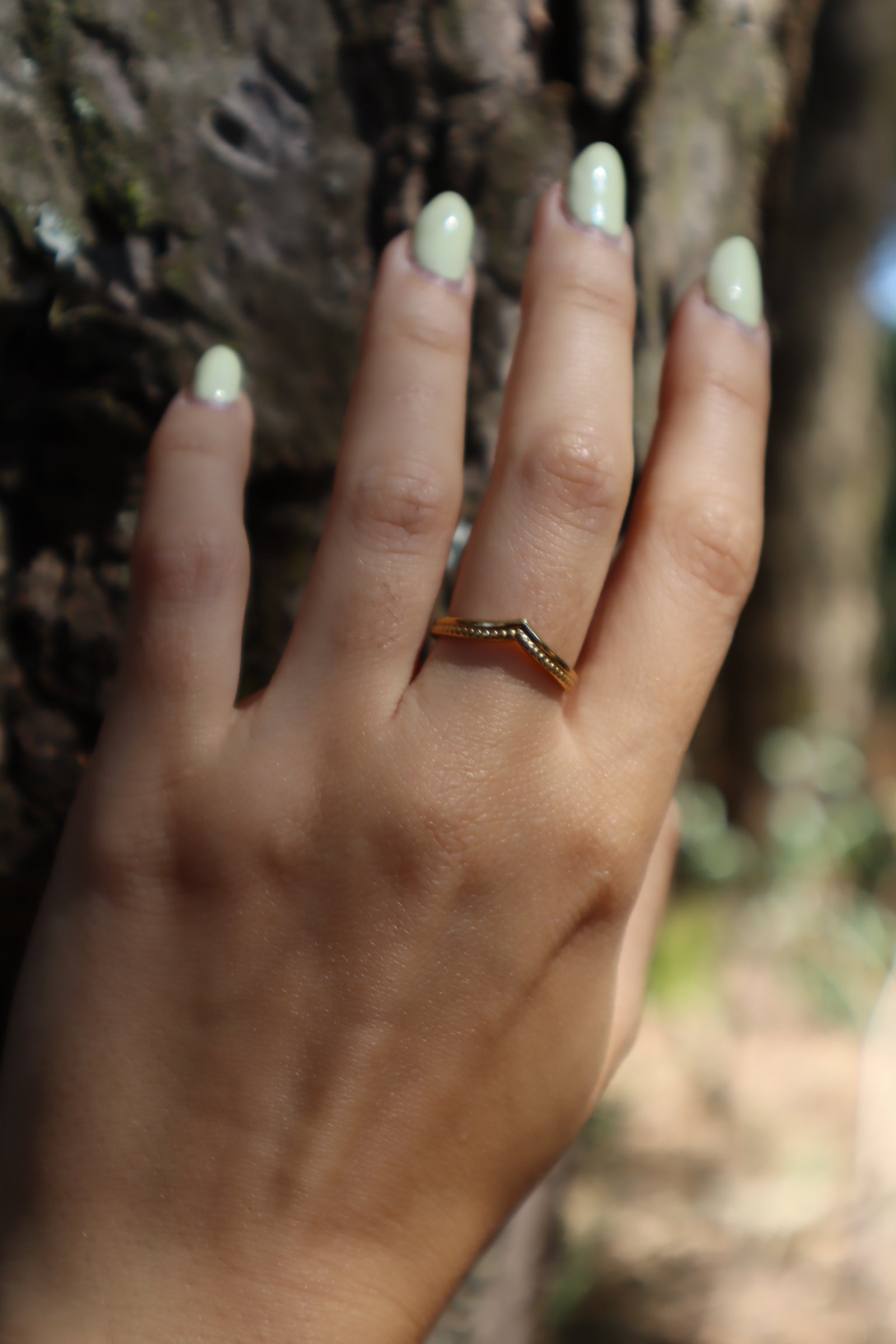 Anel dourado com duas texturas e detalhe pontiagudo.