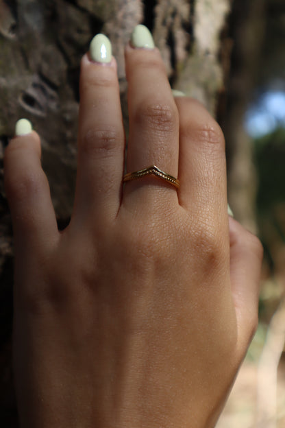 Anel dourado com duas texturas e detalhe pontiagudo.