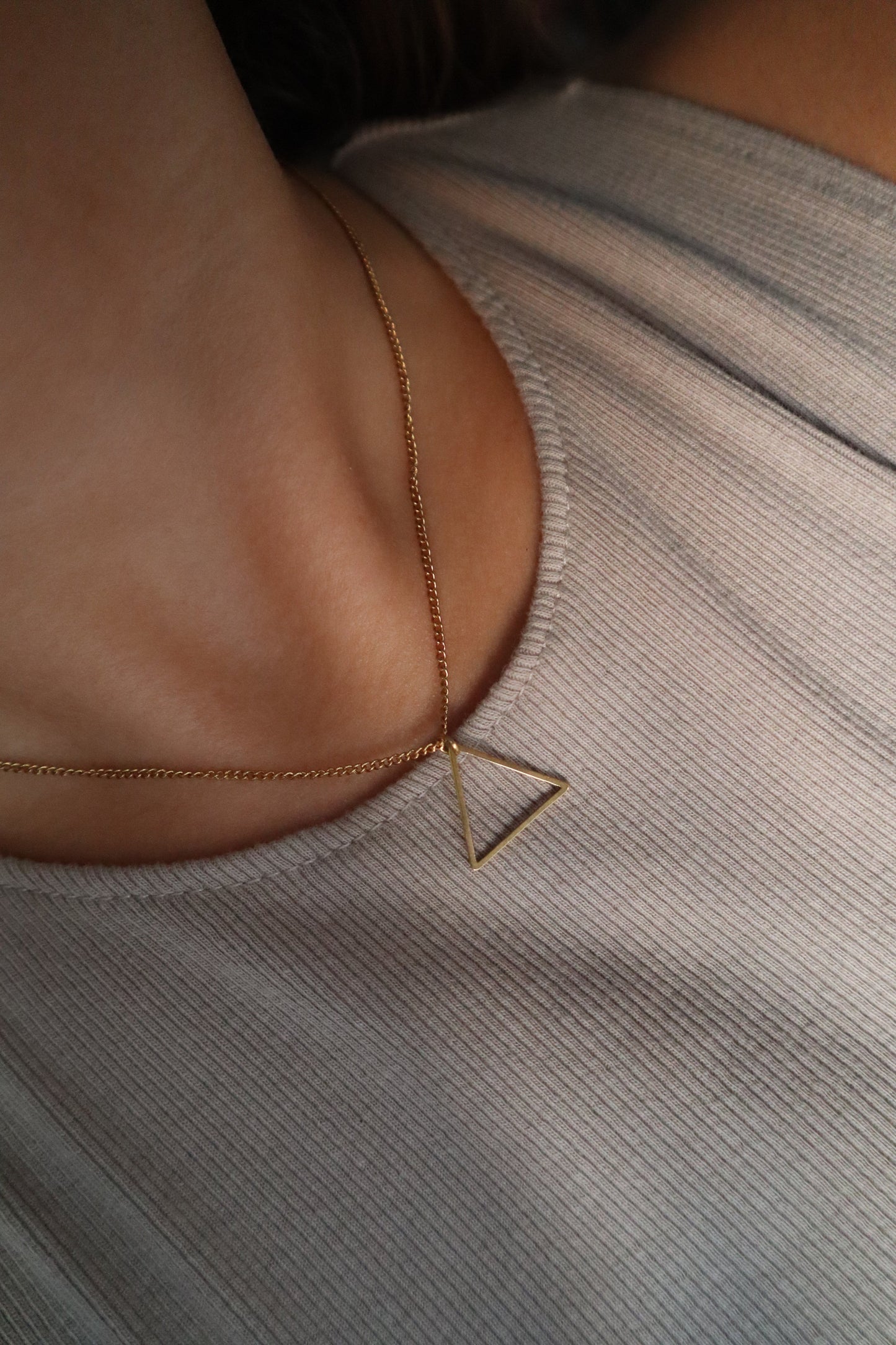 Colar dourado com corrente fina. Pendente em forma de triângulo